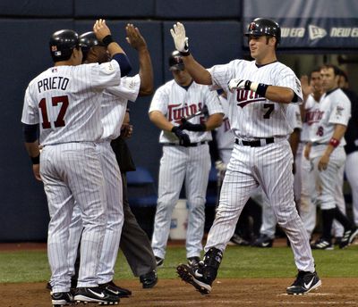 David Brewster / Star Tribune Sunday_06/06/04_Mpls. - - - - Joe Mauer (#7) celebrates with #48 Torii Hunter (behind) and #17 Alex Prieto (running for Matthew LeCroy) at home plate following his 3 run homer in the 8th inning which put the Twins in the le