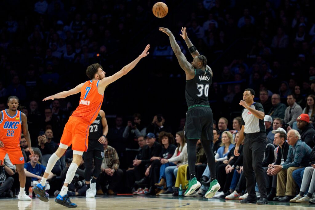 Jan 29, 2026; Minneapolis, Minnesota, USA; Minnesota Timberwolves forward Julius Randle (30) shoots a three point basket over the defense of Oklahoma City Thunder center Chet Holmgren (7) in the fourth quarter at Target Center. Mandatory Credit: Matt Blewett-Imagn Images
